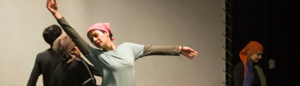 Attori in una sala prove chiara, una donna con le braccia spalancate a metà di un movimento, immagine per la domanda a cosa serve la recitazione