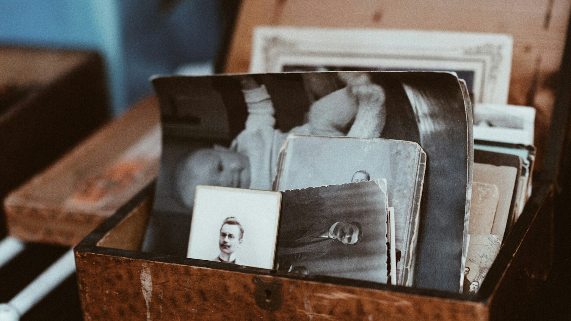 Scatola di legno piena di vecchie fotografie e ritratti in bianco e nero, la forza delle immagini che sopravvivono a chi le ha scattate