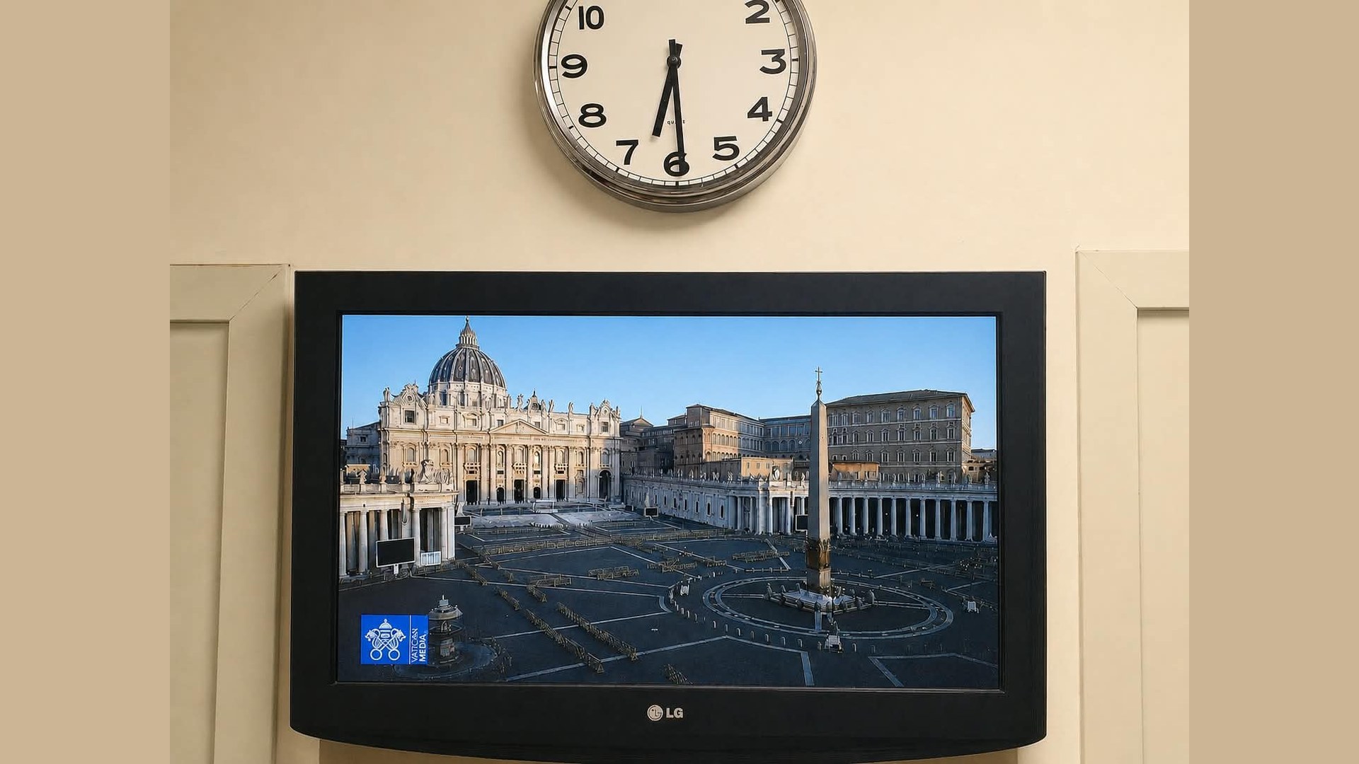 Monitor acceso su Piazza San Pietro in diretta nella reception di un hotel di Roma, con un orologio a lancette sopra