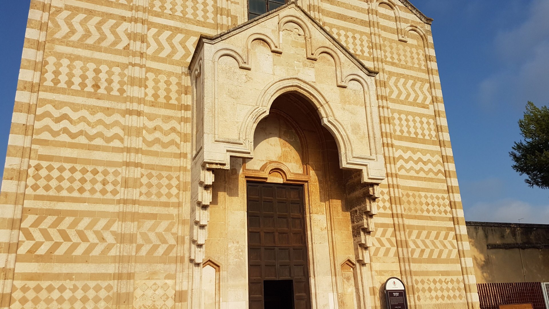 La facciata di Santa Maria del Casale a Brindisi, in fasce di carparo ocra e pietra bianca, con il portale ogivale al centro