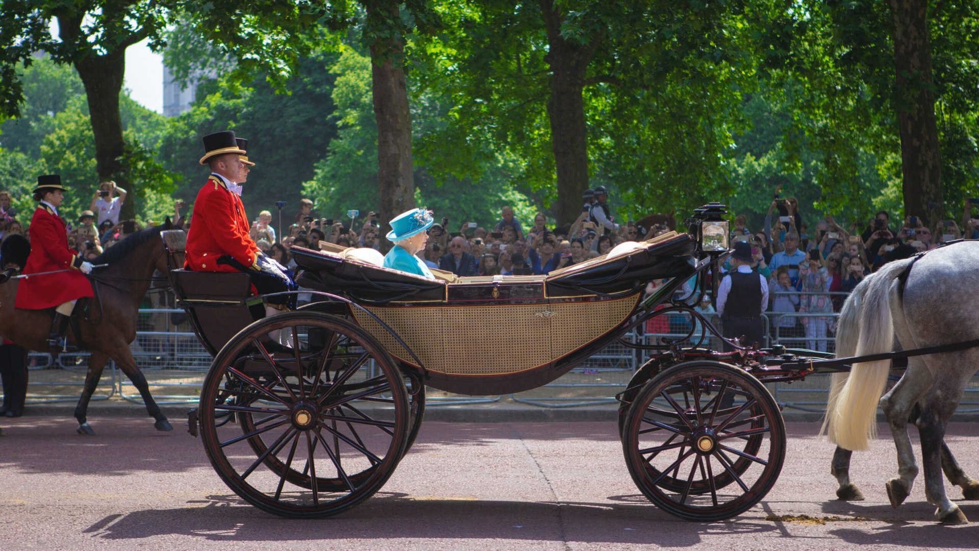 La regina Elisabetta II in carrozza scoperta davanti alla folla che la fotografa, immagine per la fine del Novecento