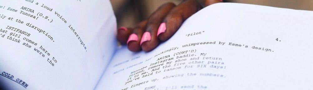 Un copione aperto tenuto in mano, con le battute stampate da memorizzare e il nome del personaggio in maiuscolo