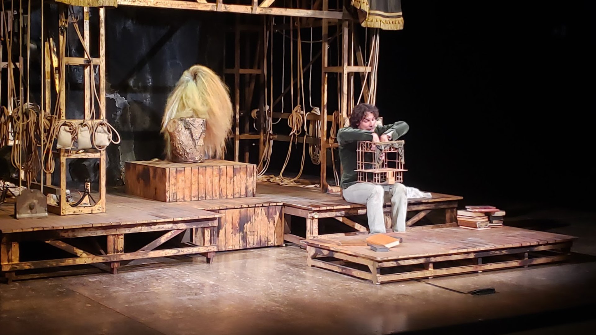 Francesco Montanari in Storia di un cinghiale, variazione su Riccardo III, seduto con un teatrino in miniatura in braccio